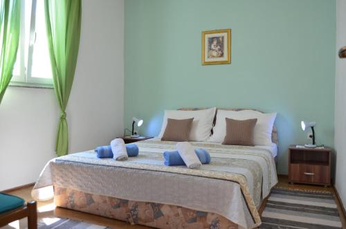 sypialnia z łóżkiem z niebieskimi poduszkami w obiekcie Apartment MARA w mieście Šilo