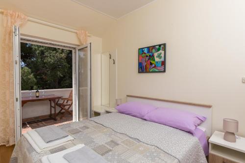 a bedroom with a bed and a window and a table at Apartment & Room Braica in Dubrovnik