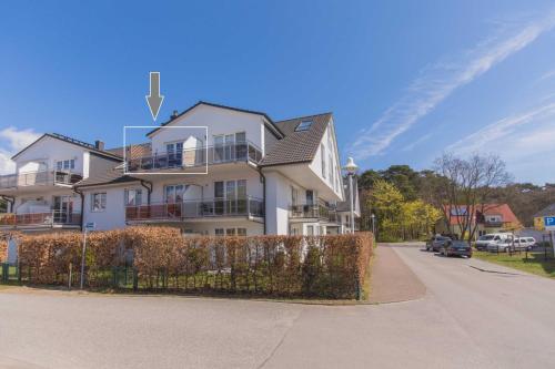 a white house with a fence in front of it at Ferienwohnung Ihr Zuhause am Meer in Thiessow