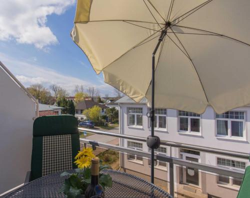 a patio table with an umbrella on a balcony at Ferienwohnung Ihr Zuhause am Meer in Thiessow