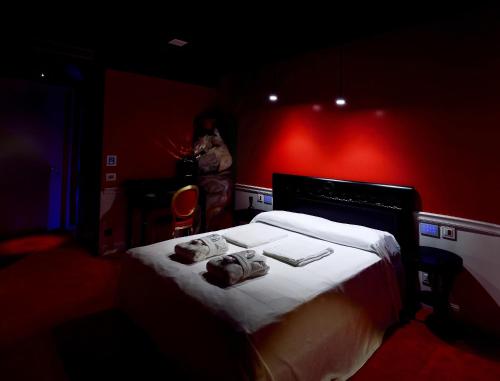 a woman standing in a red room with a bed at San Giorgio Modica Hotel in Modica