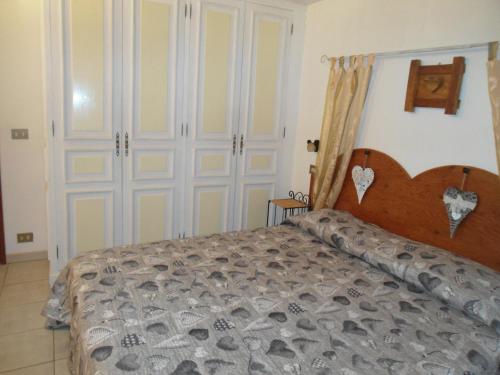a bedroom with a bed with a wooden head board at Fiocco di Neve in Montjovet