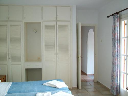 a bedroom with white cabinets and a bed and a window at Villa Pilion in Kolios