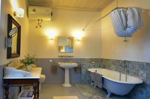 a bathroom with a tub and a sink and a toilet at Roumanades Estate in Roumanádes