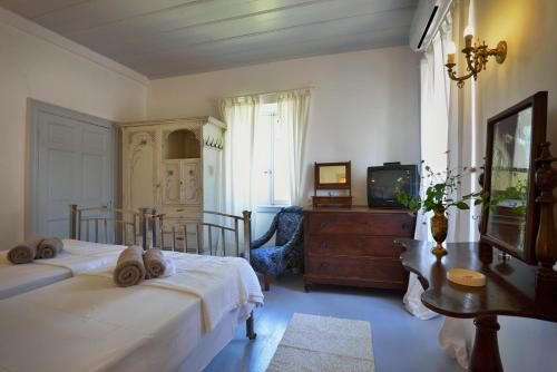 a bedroom with two beds and a tv and a dresser at Roumanades Estate in Roumanádes