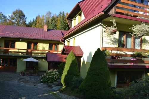 ein großes Haus mit rotem Dach und Hof in der Unterkunft Agroturystyka Oblica in Zawoja