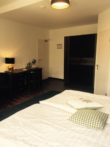a large white bed in a room with a desk at Hotel Trendtino in Eisenberg