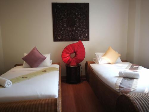 a room with two beds and a red fan at Hua Hin Blue Lagoon in Cha Am