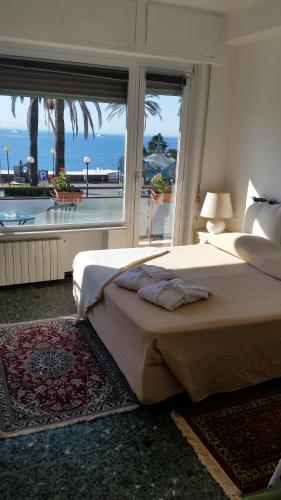 a bedroom with two beds and a large window at Il Ponentino in Varazze