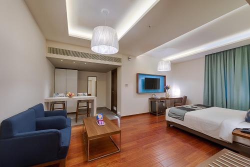 a bedroom with a bed and a couch and a table at The Belstead in Chennai