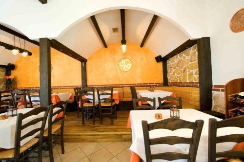 a restaurant with tables and chairs and a clock on the wall at Lydia Hotel in Krinídhes