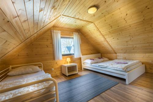 1 dormitorio con 2 camas en una cabaña de madera en Słoneczny Ogród, en Władysławowo