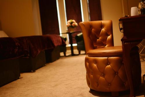 a brown chair in a living room with a couch at Rooms At Rue in Omagh