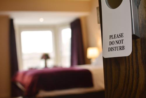 a sign that says please do not disturb in a hotel room at Rooms At Rue in Omagh