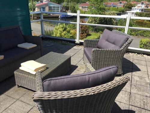 three chairs and a table and chairs on a patio at Friese Kust Villa in Workum
