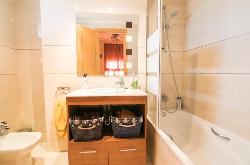ein Badezimmer mit einem Waschbecken und einer Badewanne in der Unterkunft Biopark View Apartment in Valencia