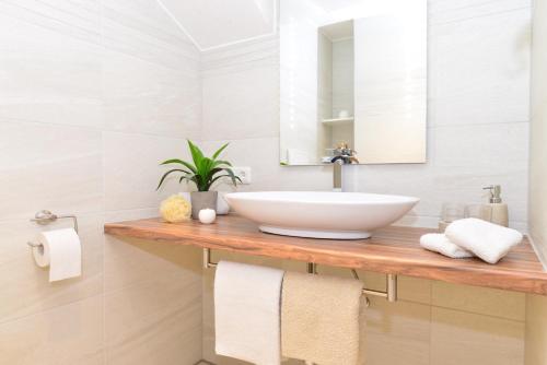 a bathroom with a sink and a mirror and towels at Sonn Alpin - Ferienwohnungen in Grän
