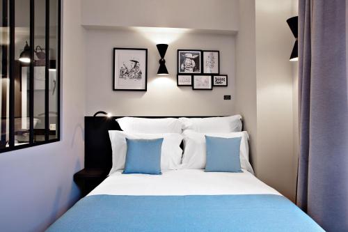 a bedroom with a bed with blue and white pillows at Boutique Hotel Villa du Taur in Toulouse