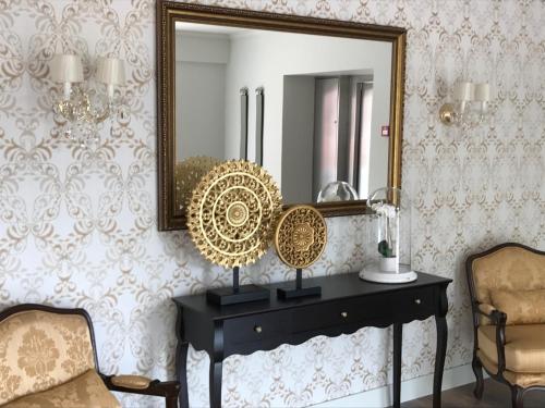 a mirror on a wall with a table and a chair at Luna Hotel Turismo in Abrantes
