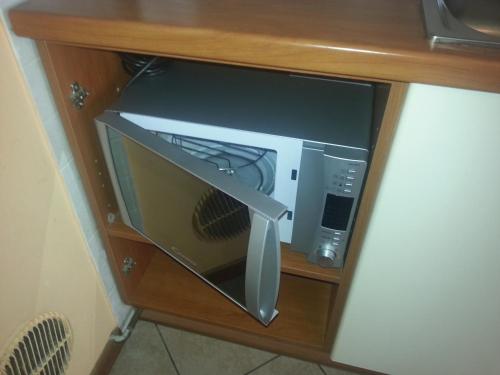 a drawer in a desk with a microwave in it at Residenza Teodolinda in Monza