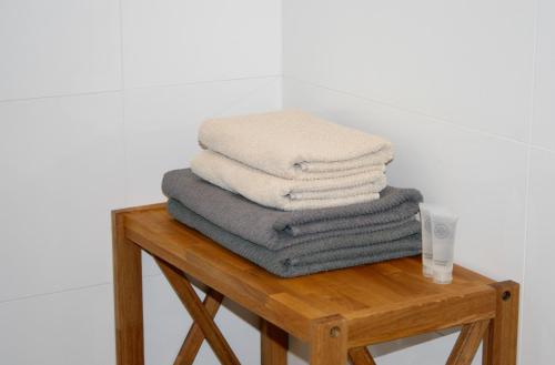 a pile of towels sitting on top of a wooden table at Design apartment in Liepāja