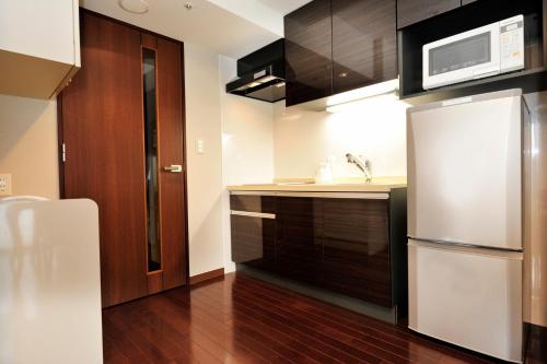 a kitchen with a refrigerator and a microwave at Hotel Global View Hakodate in Hakodate