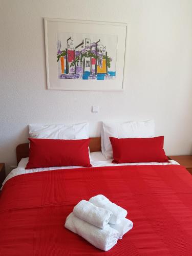 a bedroom with a red bed with towels on it at Apartments Antonio in Cavtat