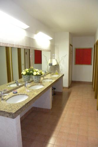 a bathroom with three sinks and two mirrors at Hotel Santa Cruz in Lignano Sabbiadoro