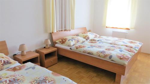 a small bedroom with two beds and two lamps at Holiday House Kanalec in Drežnica