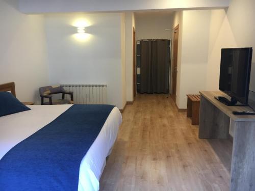 a hotel room with a bed and a television at Hotel Marxant in Tavascan