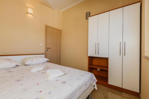 een slaapkamer met een bed en een witte kast bij Villa Joma 2 in Trogir