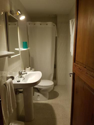 a bathroom with a white sink and a toilet at Hostal Restaurante Playa in Colònia de Sant Jordi