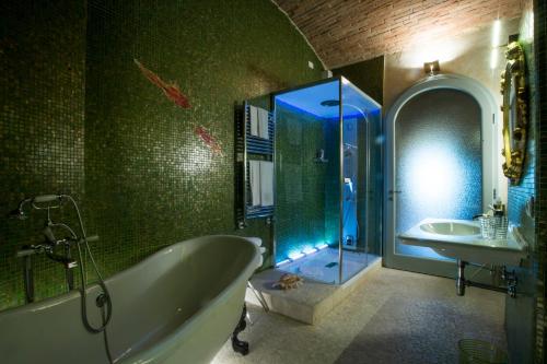a bathroom with a tub and a sink and a shower at Palazzo Pacini in Colle Val D'Elsa