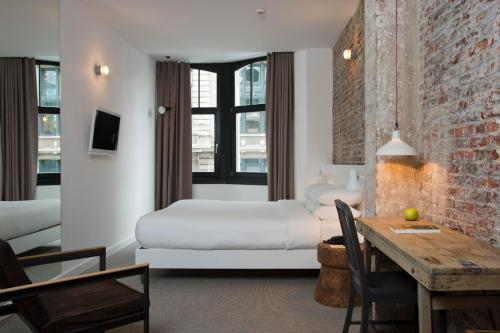 Habitación de hotel con cama y mesa de comedor en 9Hotel Central, en Bruselas