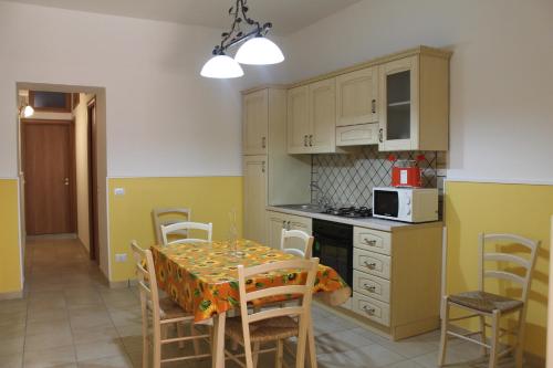 陶爾米納的住宿－Casa vacanze "Terra del sole"，厨房配有桌椅和微波炉。