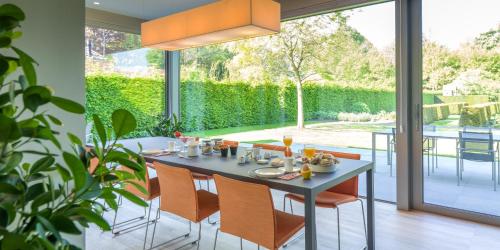 uma sala de jantar com mesa e cadeiras e uma grande janela em B&B Antares em Bruges