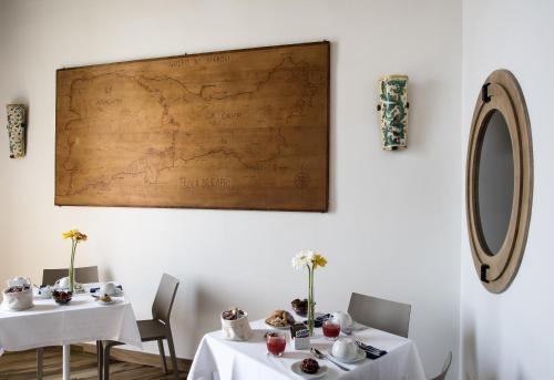 a dining room with two tables and a map on the wall at Mareluna Suite de Charme in Naples