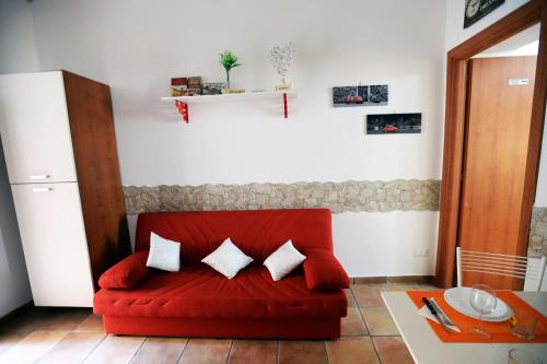 a red couch with three pillows in a living room at Little House Roma in Rome
