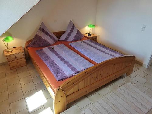 ein großes Holzbett in einem Schlafzimmer mit zwei Lampen in der Unterkunft Haus Sonntag in Frickingen