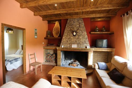 een woonkamer met open haard en een bank bij Casa Rural El Bonito in Cazalla de la Sierra