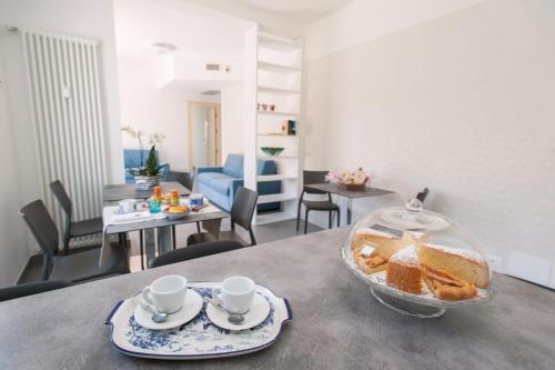 a table with a bowl of bread and two cups of coffee at B&B Ligure Rooms in Pietra Ligure