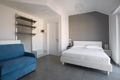 a bedroom with a bed and a blue chair at B&B Ligure Rooms in Pietra Ligure
