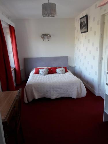 une chambre avec un lit avec deux oreillers dessus dans l'établissement Chambres d'Hôtes du Moulin du Vey, à Clécy