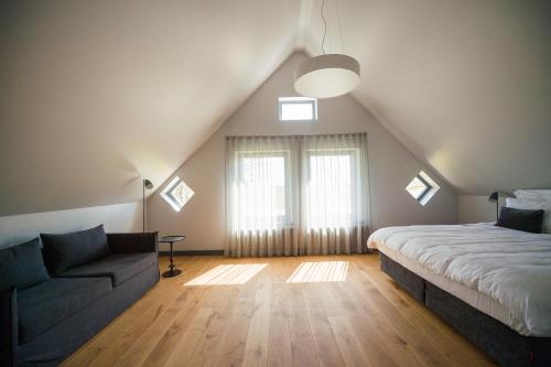 Zoltners Hotel في تيرفيتي: غرفة نوم في العلية مع سرير وأريكة
