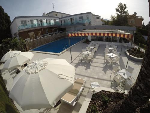 a patio with umbrellas and tables and a pool at Hotel Complejo Los Rosales in Torremolinos