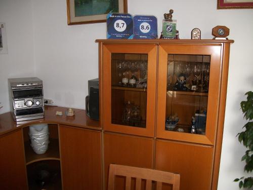 a wooden cabinet with glass doors and a microwave at B&B A Un Passo Da in Casale sul Sile