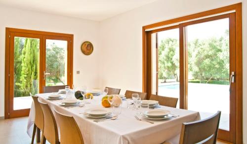 a dining room with a white table and chairs at Finca Victoria in Alcudia