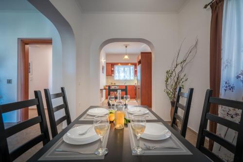 a dining room table with wine glasses on it at Aelia Villa in Kallithea