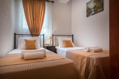 sypialnia z 2 łóżkami i pomarańczową pościelą w obiekcie Aelia Villa w mieście Kallithea