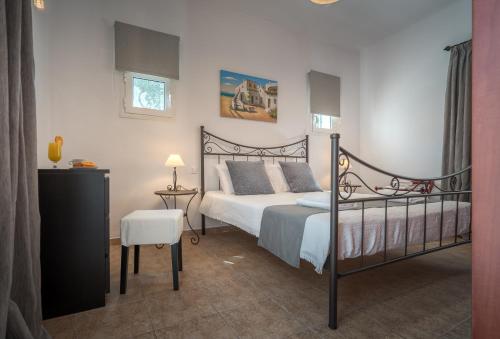 a bedroom with a bed and a table and a chair at Aelia Villa in Kallithea